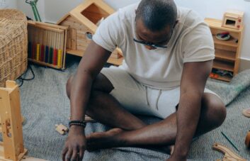african american man sitting on floor near wooden details