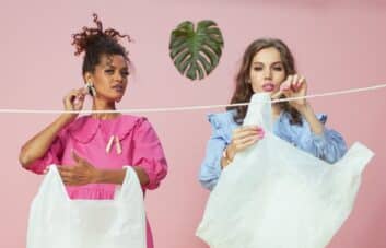 two women hanging plastic bags on the clothesline